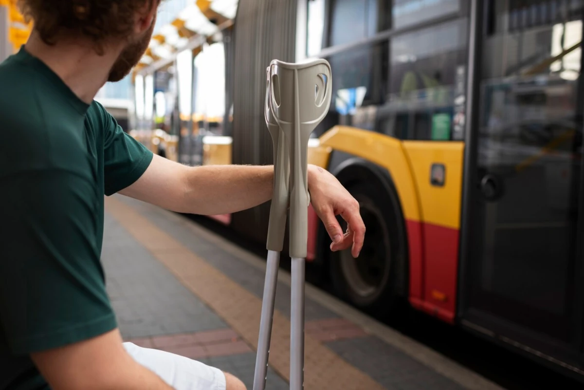 przewoz osob do sanatorium - osoba o kulach czekajaca na przystanku na autobus komunikacji miejskiej przewoz osob do sanatorium - osoba o kulach czekajaca na przystanku na autobus komunikacji miejskiej